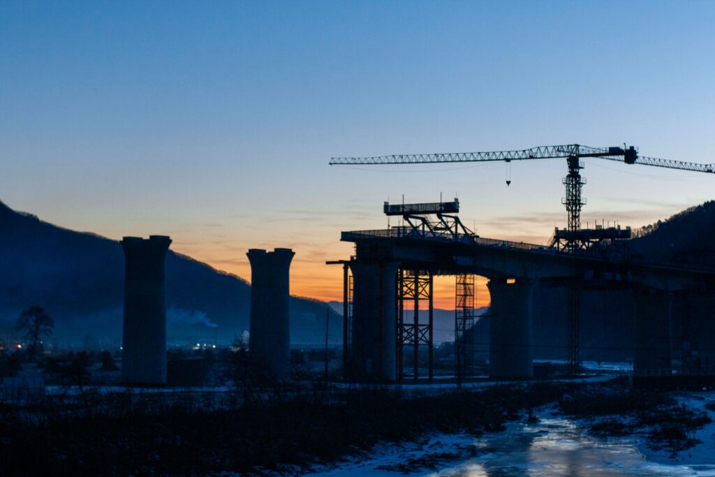 Bouwkraan boven het water bij een brug in aanbouw